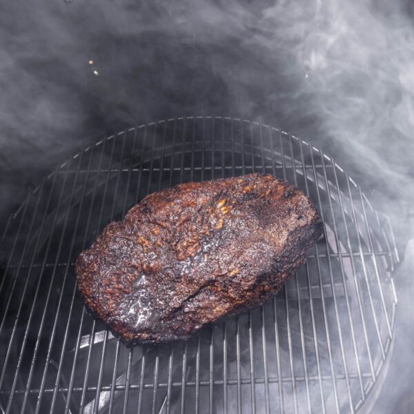 Una jugosa pieza de carne ahumándose en la parrilla de la Parrilla de Barril Champion de Pit Boss.