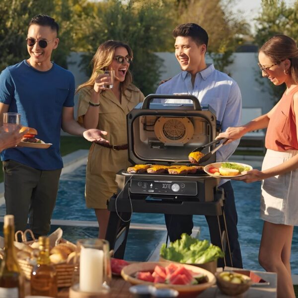 Grupo de amigos disfrutando de una barbacoa al aire libre junto a una piscina, cocinando hamburguesas con una barbacoa Ninja Woodfire.