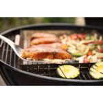 Primer plano de filetes de pescado, aguacate y vegetales asados en la barbacoa de carbón Weber Master-Touch de 67 cm.