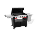 Plancha Weber SLATE GPSB 76 cm Premium con tapa abierta, superficie de cocción antiadherente, quemador lateral y espacio de almacenamiento integrado.