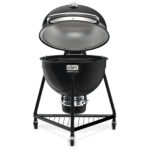 Barbacoa Summit Kamado E6 de Weber con la tapa abierta, mostrando la rejilla de cocción y el interior de doble pared.