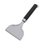 Rascador para planchas Weber con hoja de acero inoxidable, mango negro ergonómico y gancho para colgar.