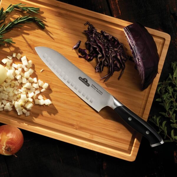 Cuchillo Santoku de Napoleon sobre una tabla de cortar de bambú junto a ingredientes frescos picados, resaltando su uso práctico y diseño elegante.