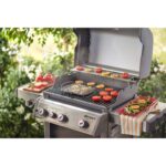 Cesta para asar Weber en una parrilla Spirit, cocinando tomates y otras verduras con resultados dorados y uniformes.