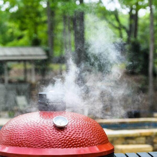 El ducto superior Kontrol Tower del Kamado Big Joe II liberando humo durante la cocción.