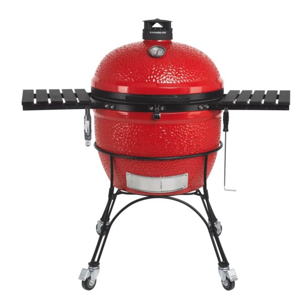 Vista frontal del Kamado Big Joe II, una parrilla de cerámica roja con estantes laterales plegables y ruedas para fácil movilidad.