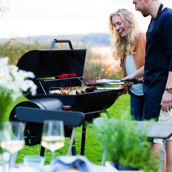 Una pareja cocinando juntos en la barbacoa Black Taurus 660+, disfrutando del proceso tanto como de la comida.