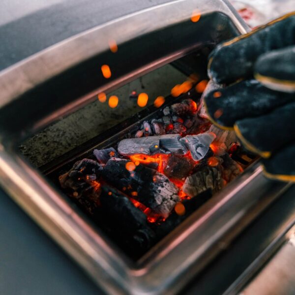 Carbón encendido en el horno de pizza Ooni Karu 12G alcanzando alta temperatura para una cocción rápida