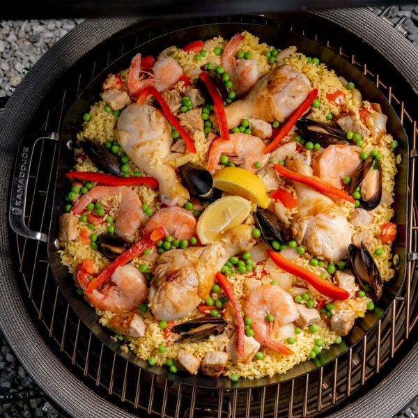 Paella de mariscos y pollo en una paellera Kamado Joe, vista desde arriba.