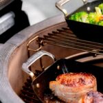Parrilla Kamado Joe con sartenes de media luna "Karbon Steel", cocinando vegetales y medallones de carne.