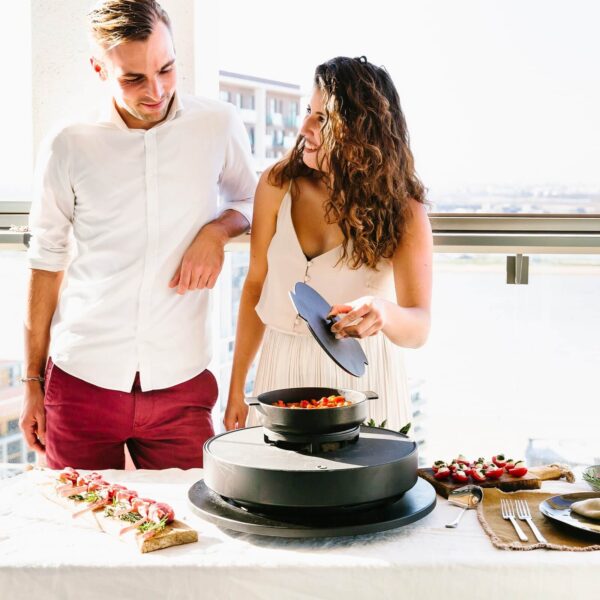 Pareja cocinando en el set de cazuela de hierro fundido OFYR Tabl'O, mientras preparan una comida al aire libre con ingredientes frescos.