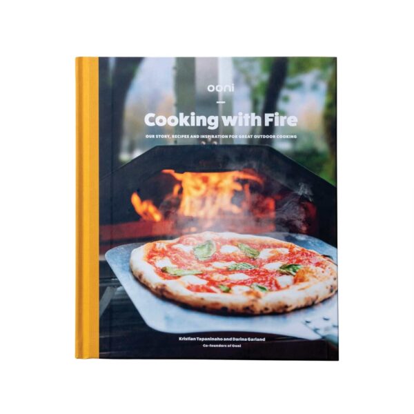 Portada del libro 'Cooking with Fire' de los cofundadores de Ooni, Kristian Tapaninaho y Darina Garland, mostrando una pizza napolitana perfectamente cocinada sobre un fondo de llamas vivas, simbolizando la cocina al aire libre.