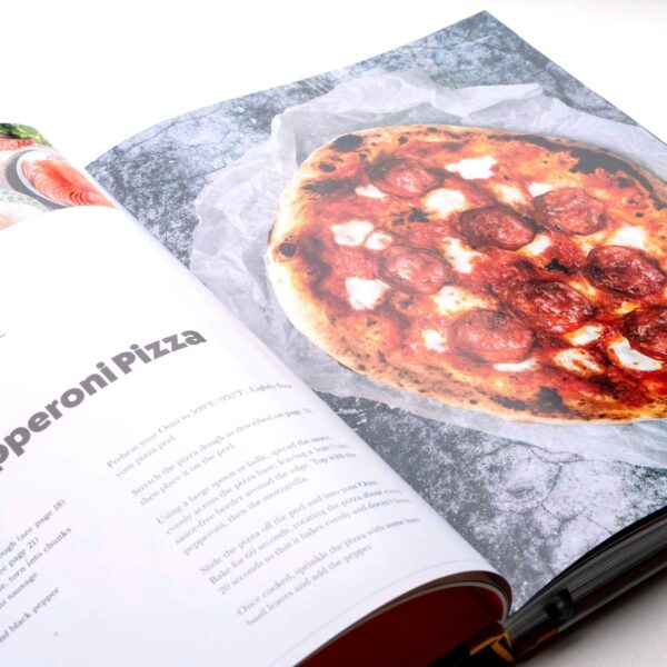 Página de receta de Pepperoni Pizza en el libro 'Cooking with Fire', mostrando una apetitosa pizza en detalle vívido y texto explicativo