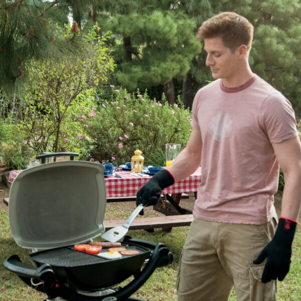 Hombre cocinando en una barbacoa Weber con la Plancha de Hierro Colado Q 1000 en un entorno al aire libre.