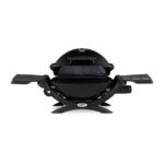 Barbacoa de gas Weber Q 1200 con tapa abierta y rejillas de cocción visibles.