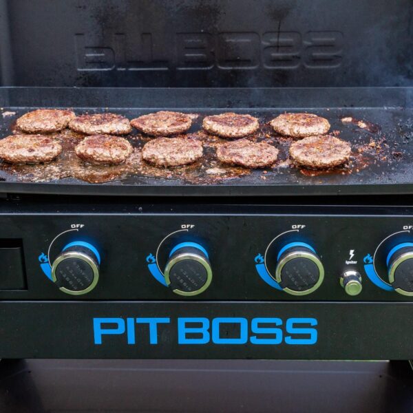 Hamburguesas cocinándose en la plancha Pit Boss, perfectas para una comida al aire libre.