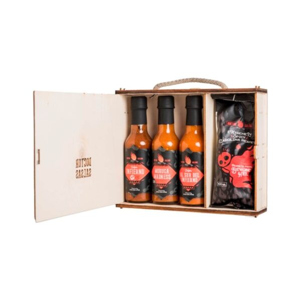 Caja de madera con tres botellas de salsa picante y un paquete de cacahuetes súper picantes. Las salsas son del Infierno, Moruga Madness y Al Sur del Infierno, y el paquete de cacahuetes es Carolina Reaper.