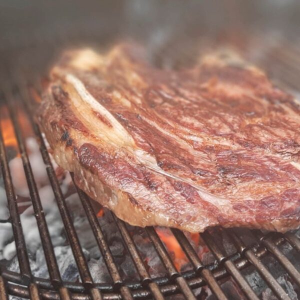 Carne asada en parrilla con carbón encendido