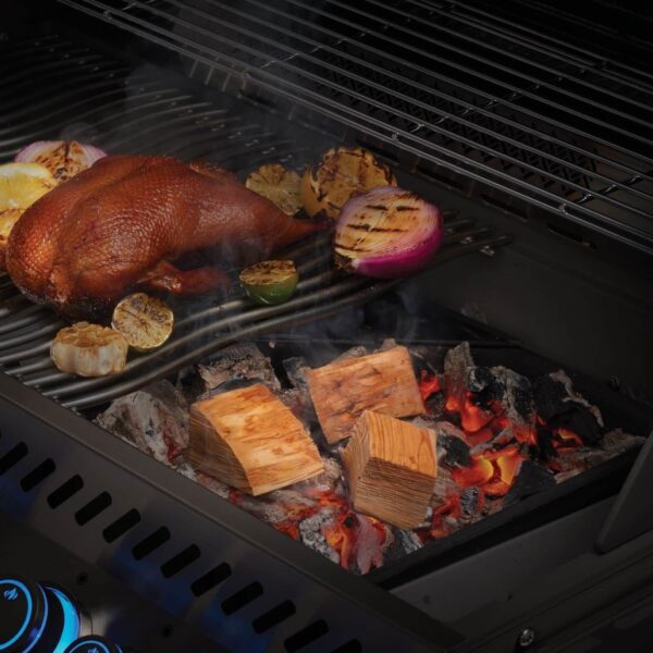 Trozos de madera de cerezo ardiendo en una parrilla de carbón junto a un pato ahumado y vegetales asados, creando un ambiente de sabor intenso y delicioso.