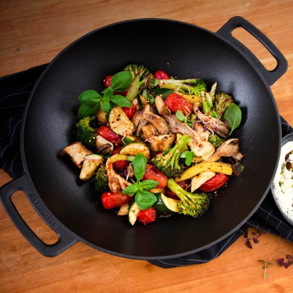 Colorido salteado de verduras en el Wok de Hierro Fundido LANDMANN sobre una cocina de madera.