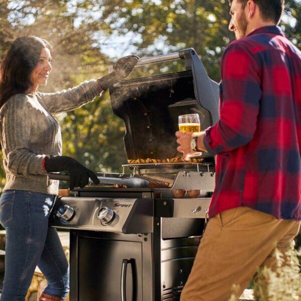 Dos personas disfrutando de una parrillada al aire libre con la barbacoa de gas Weber Spirit E-215 GBS.