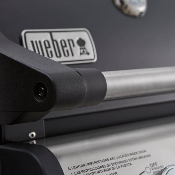 Primer plano del logo de Weber y el asa de la tapa en la barbacoa Spirit E-215 GBS.