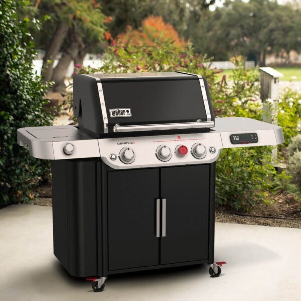 Barbacoa Weber Genesis EPX-335S de color negro, ubicada en un patio al aire libre, rodeada de vegetación, con el panel de control digital mostrando 350 °F.