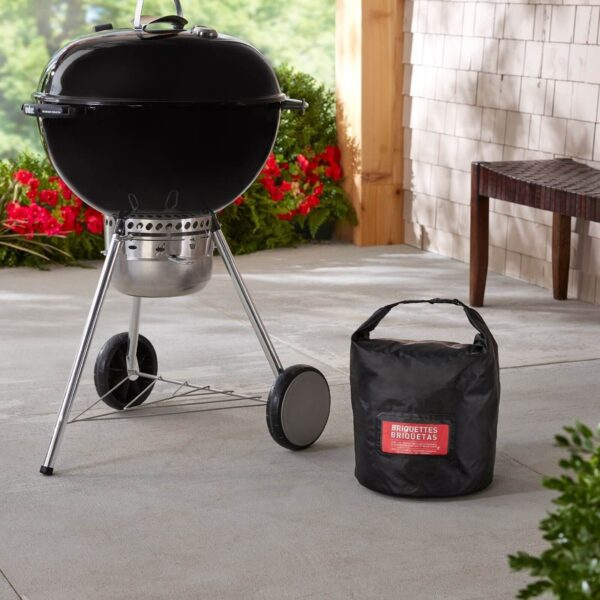 Bolsa de almacenamiento Weber con briquetas de carbón junto a una barbacoa en una terraza exterior.