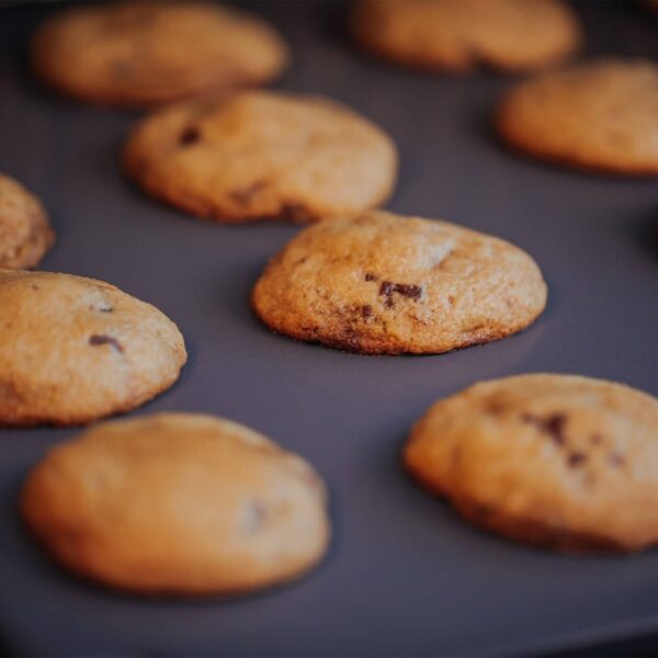 Galletas recién horneadas con chispas de chocolate sobre la piedra para pizza esmaltada de Weber.