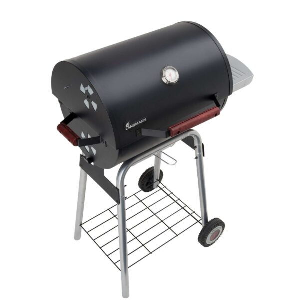 Barbacoa Black Taurus 440 de carbón en color negro con tapa cerrada, termómetro en la tapa, una mesa lateral de madera y ruedas para fácil transporte.