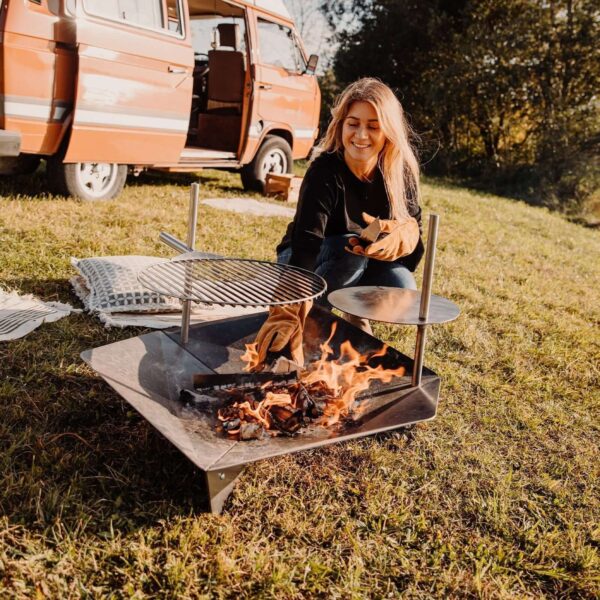 Mujer sonriente preparando una barbacoa con guantes Höfats.