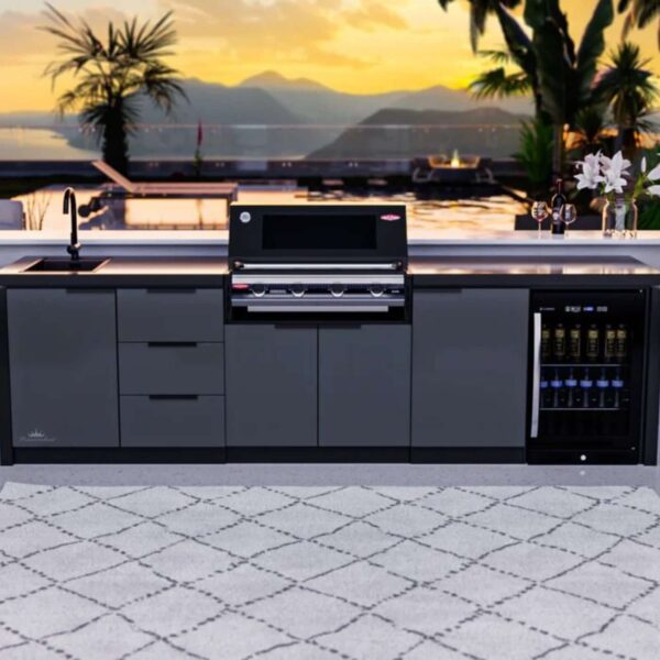 Cocina de exterior Cabinex® frente a una vista panorámica al atardecer, equipada con barbacoa, fregadero y nevera, en un ambiente lujoso al aire libre.