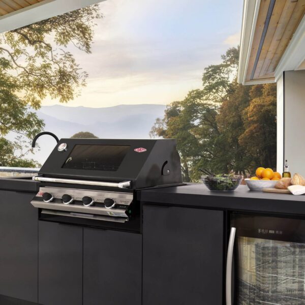 Cocina de exterior Cabinex® con barbacoa, fregadero y nevera integrada, ubicada en una terraza con vista a un paisaje natural de árboles y montañas.