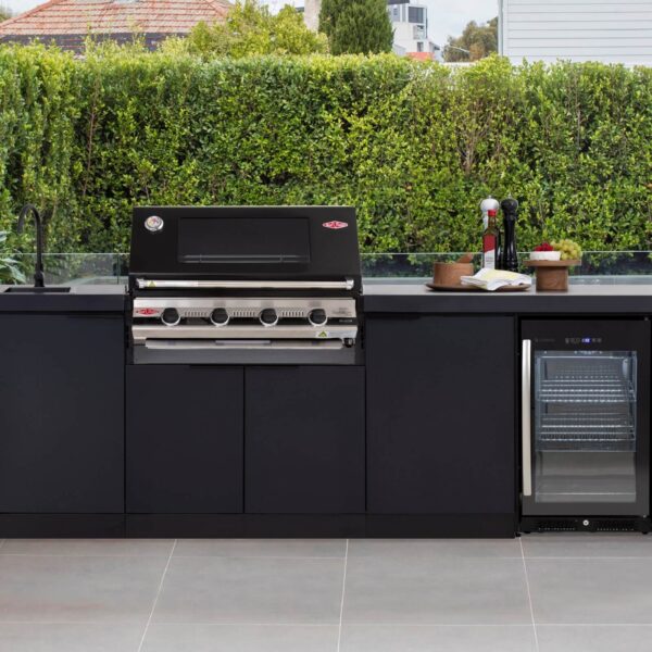 Cocina de exterior Cabinex® instalada junto a una piscina, con barbacoa de alto rendimiento, fregadero negro mate y nevera integrada.