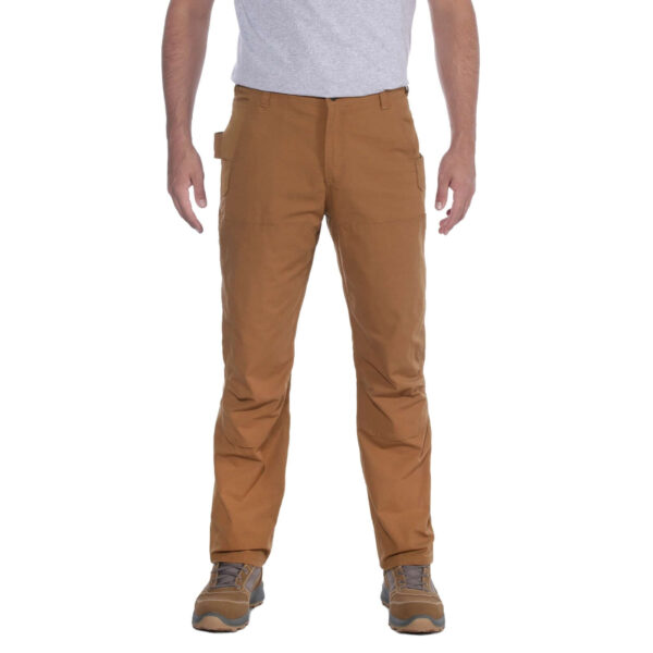 Hombre vistiendo pantalones técnicos marrones Carhartt con refuerzos y bolsillos utilitarios.