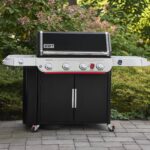Barbacoa Weber Genesis EP-435 con tapa cerrada en un jardín, lista para comenzar a cocinar.