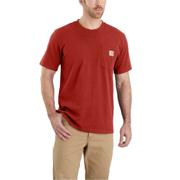 Hombre con camiseta Carhartt K87 de manga corta en color rojo chili, con bolsillo lateral y logo de la marca, combinada con pantalones beige