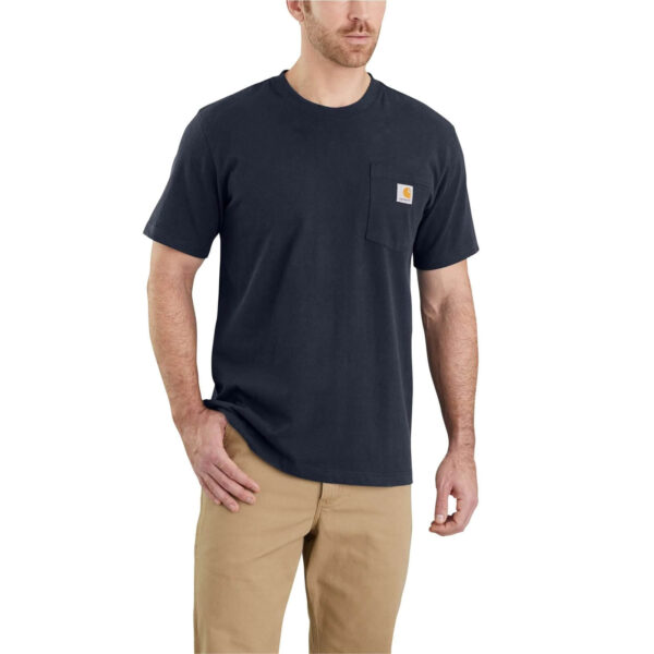 Hombre con camiseta Carhartt K87 de manga corta en color azul marino, con bolsillo lateral y logo de la marca, combinada con pantalones beige