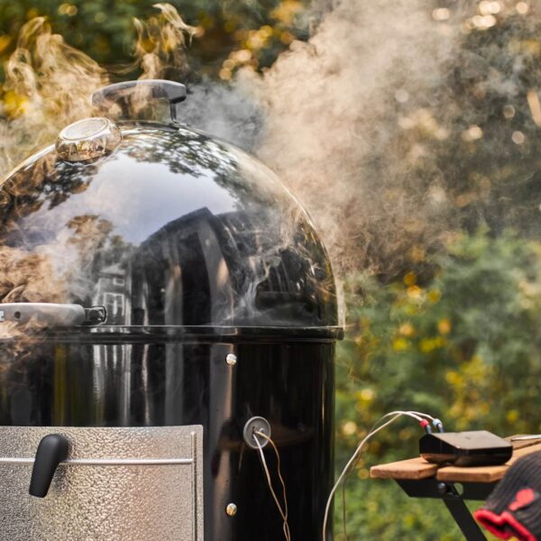 Parrilla ahumadora en funcionamiento con el Weber Connect Smart Grilling Hub monitoreando la temperatura.