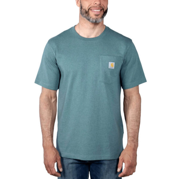 Hombre con camiseta Carhartt K87 de manga corta en color alpino marino jaspeado, con bolsillo lateral y logo de la marca, combinada con jeans