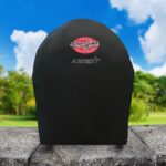 Funda Char-Griller AKORN Junior al aire libre sobre una superficie de piedra, con cielo despejado de fondo.