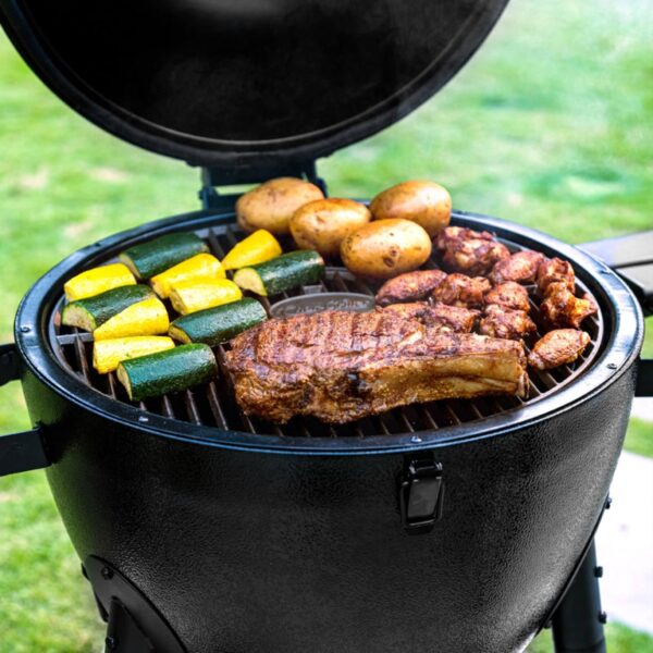 Vista superior del Kamado Akorn Normal de CharGriller, con carne, papas y vegetales cocinándose en la parrilla.