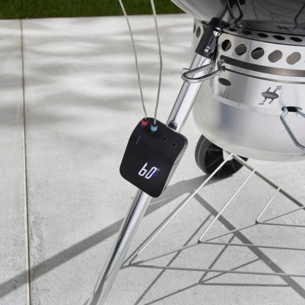 Weber Connect Smart Grilling Hub instalado en una pata de barbacoa de carbón con sonda de temperatura conectada.