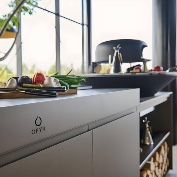 Detalle de la cocina de exterior OFYR Cozinha Sylt con encimera y alimentos frescos preparados para cocinar