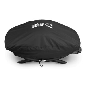 Funda Weber® Premium Q2000 negra ajustada sobre una barbacoa de la Serie Q, con logo blanco en la parte superior y cordón de sujeción en la base.