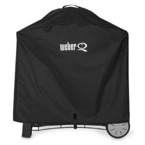 Funda Weber® Premium Q3000/Q2000 negra cubriendo una barbacoa con carro, con el logo blanco en la parte superior y ruedas visibles en la base.