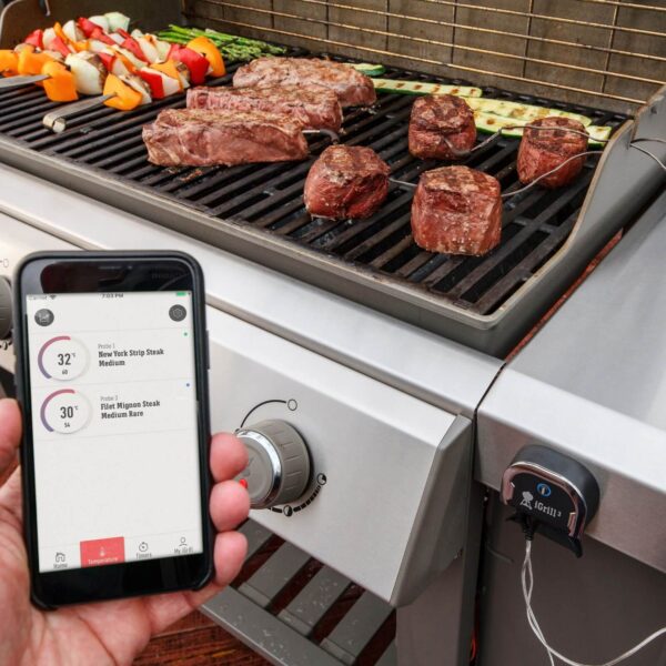 Termómetro iGrill 3 de Weber integrado en una parrilla de gas, monitoreando la temperatura de la carne a través de un smartphone.