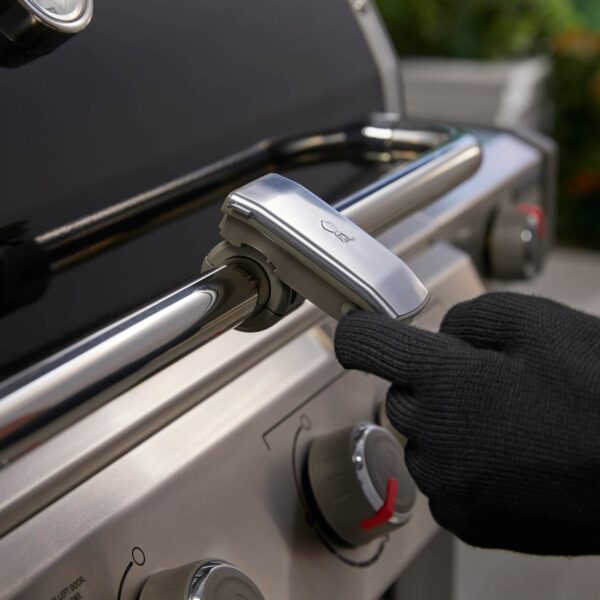 Ajuste de la Lámpara Grill 'N Go de Weber en el asa de una barbacoa de gas.