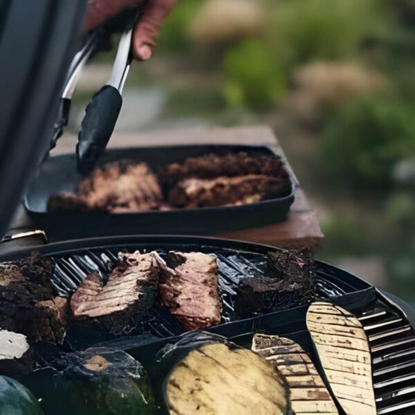 Carne y vegetales asados sobre una plancha de hierro fundido en una parrilla al aire libre.