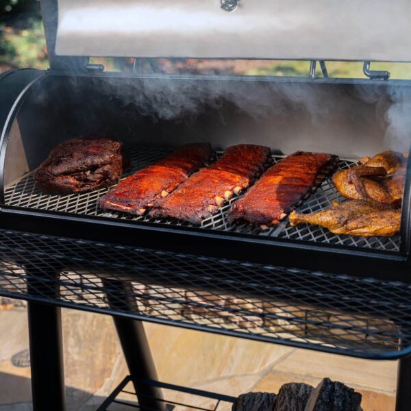 Costillas, brisket y pollo ahumándose en la barbacoa Competition Pro de Char-Griller con la tapa abierta.